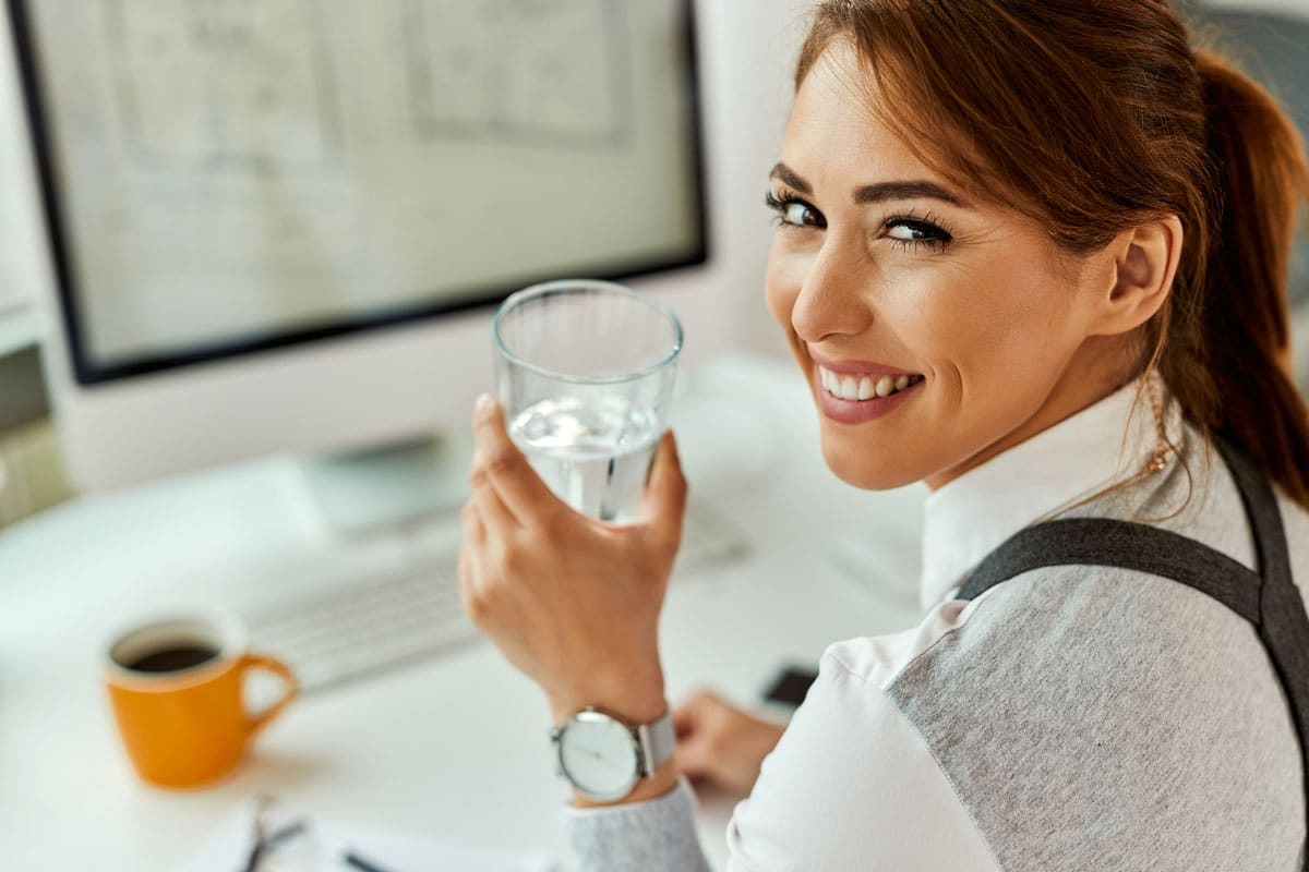 happy business woman holding glass of water